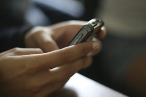 text messaging image of person using cell phone to text message